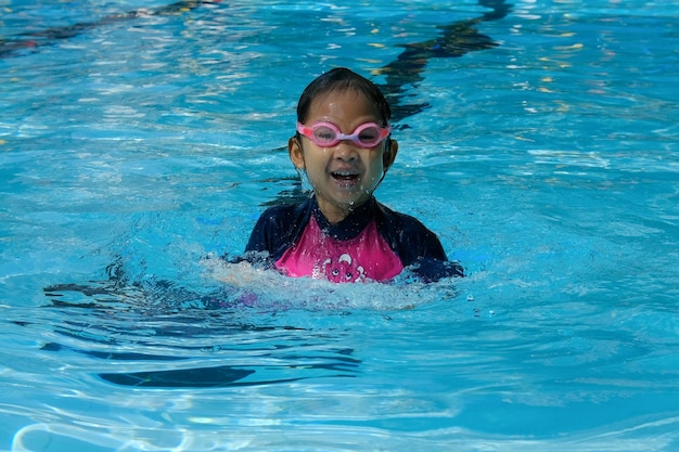 Портрет веселой девушки, плавающей в бассейне