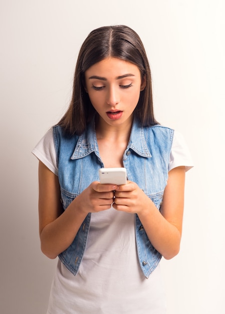 Portrait of cheerful girl teenager using the phone.