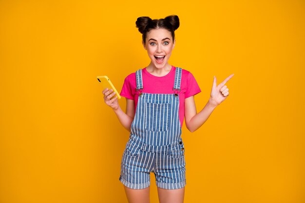 Portrait of cheerful girl use cell phone show ad copyspace