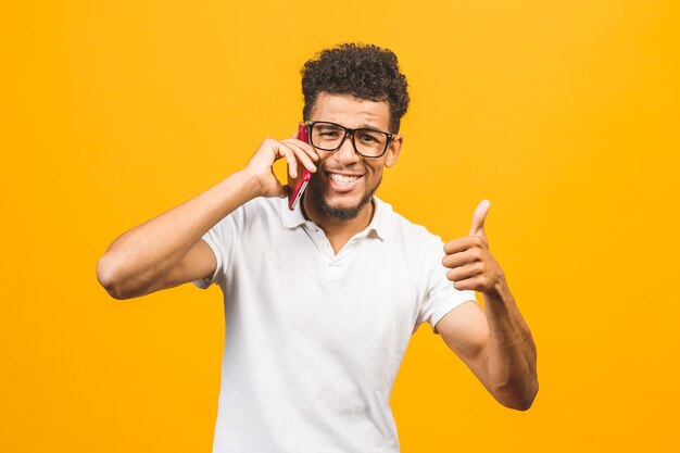 Portrait of a cheerful guy talking on mobile phone