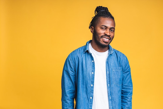 Foto ritratto di un giovane uomo di colore afroamericano sorridente felice allegro che sta isolato sopra fondo giallo.