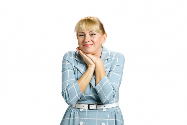 Portrait of cheerful mature woman. Adult woman clasped her hands under chin isolated on white.