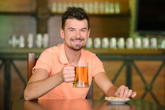 Portrait of cheerful men drinking beer at the bar.