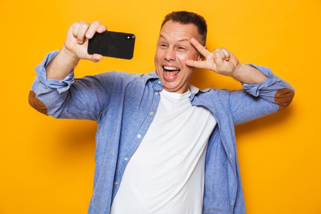portrait of a cheerful middle aged man taking a selfie
