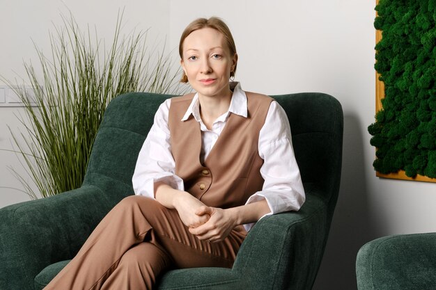 Portrait of cheerful middle aged woman in office rest room