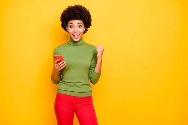 portrait of cheerful positive cute pretty sweet woman smiling toothily expressing positive emotions on face in red trousers.