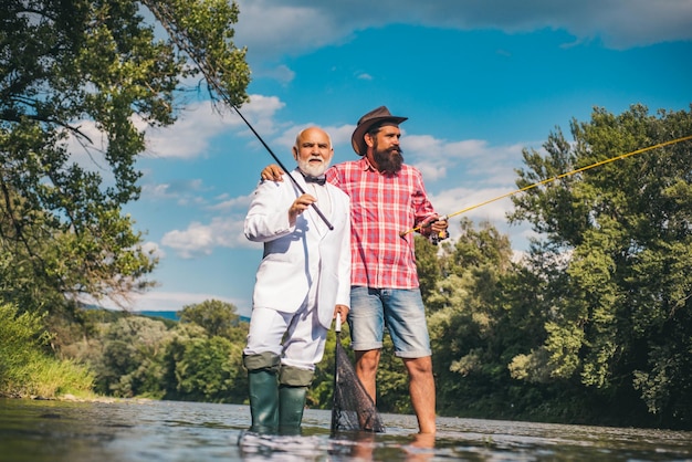 Portrait of cheerful senior man fishing grandfather and son fishermans young man and an old man fish