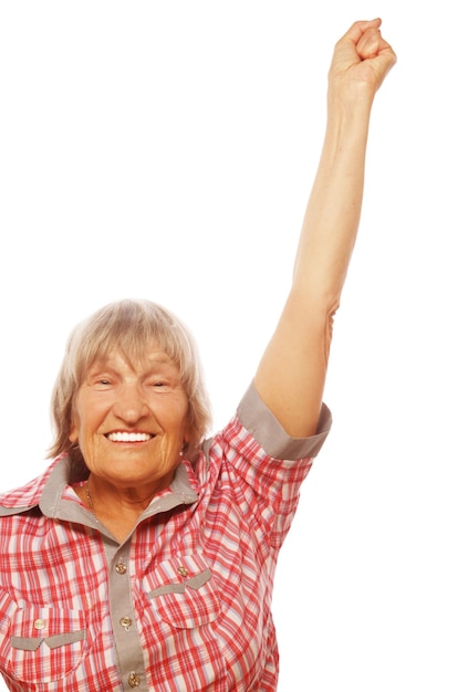 Portrait of a cheerful senior woman gesturing victory over a white background