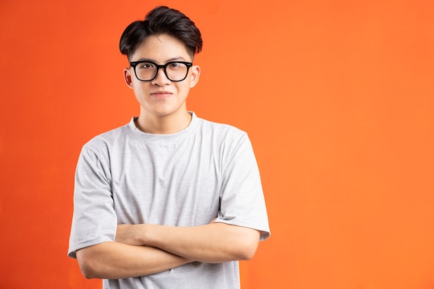 Portrait of cheerful smiling Asian man, isolated on orange background