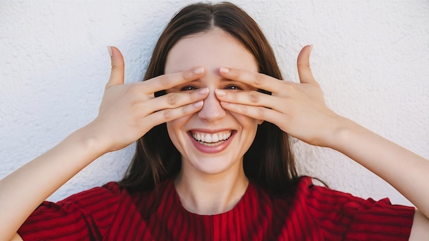 Portrait of cheerful smiling woman express happiness and joy looking through fingers over eye and g