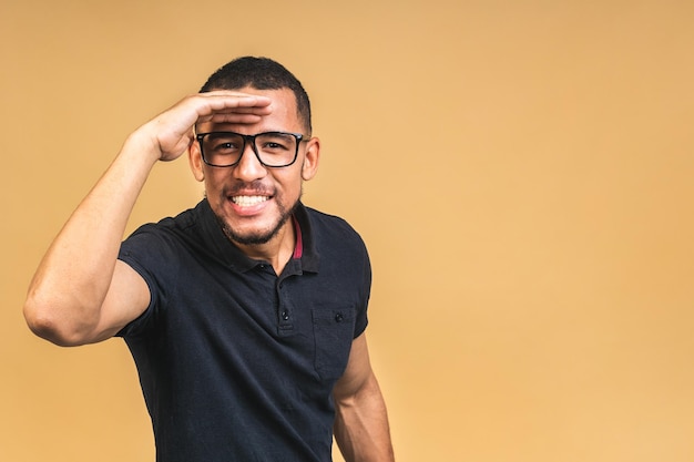 Portrait of a cheerful smiling young african american black man standing isolated over beige background