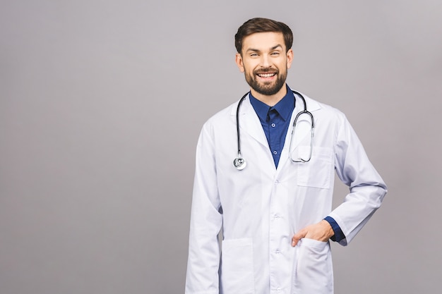 Portrait of cheerful smiling young doctor with stethoscope over neck in medical coat