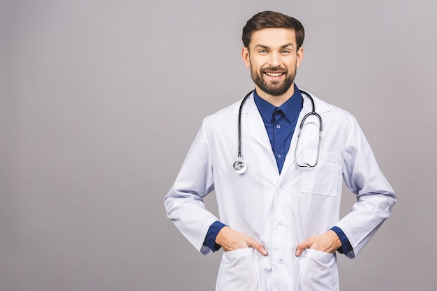 Ritratto di giovane medico sorridente allegro con lo stetoscopio sopra il collo in cappotto medico