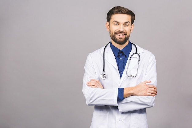 Portrait of cheerful smiling young doctor with stethoscope over neck in medical coat