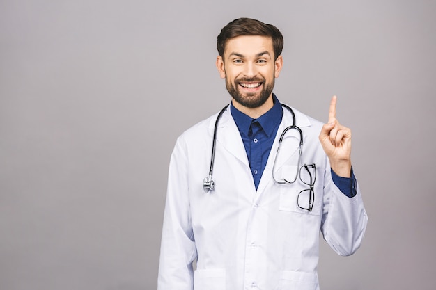 Portrait of cheerful smiling young doctor with stethoscope over neck in medical coat