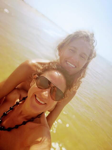 Portrait of cheerful two women at beach