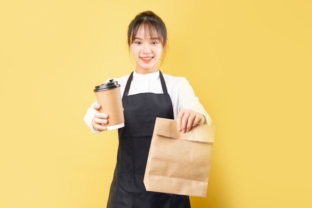 Portrait of cheerful waitress on yellow background