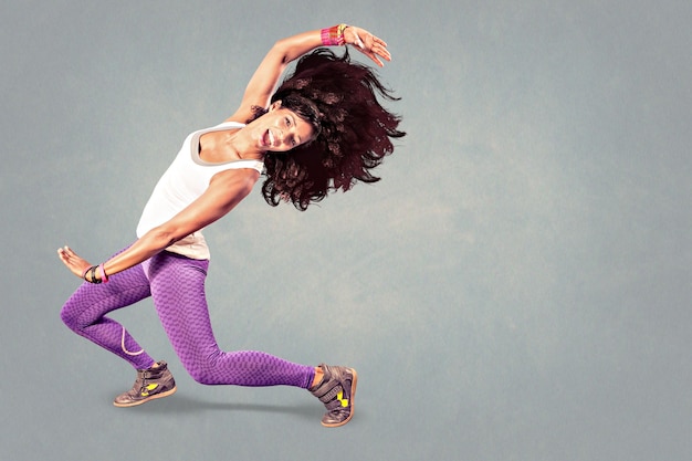 Photo portrait of cheerful woman exercising against gray background