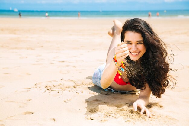 Photo portrait of cheerful woman lying at beach