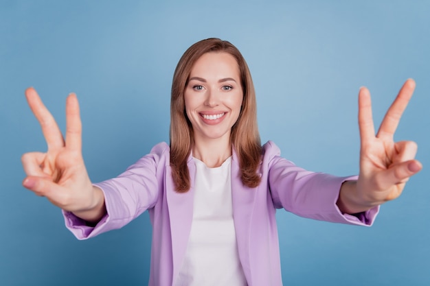 Portrait of cheerful woman show two v-signs toothy beaming smile