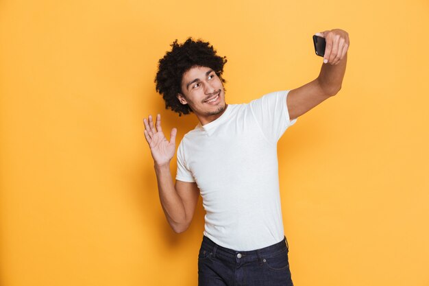 Portrait of a cheerful young african guy taking a selfie