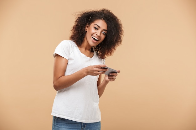 Portrait of a cheerful young african woman playing games