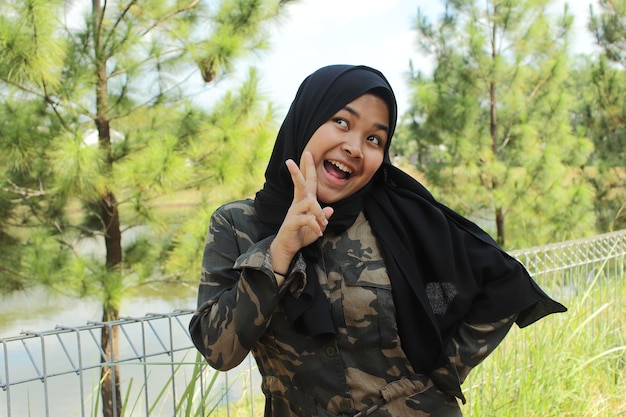 Portrait of cheerful young asian girl wearing hijab on park