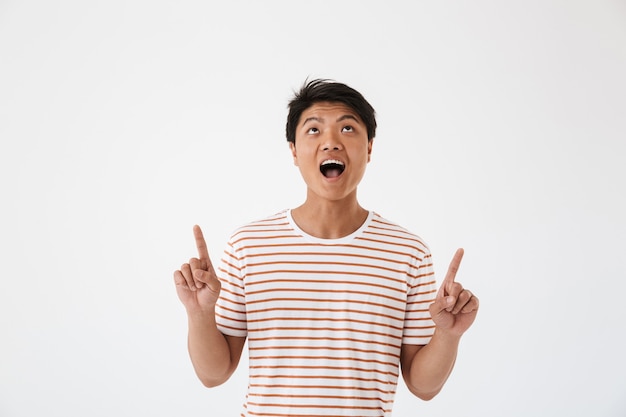 Portrait of a cheerful young asian man pointing