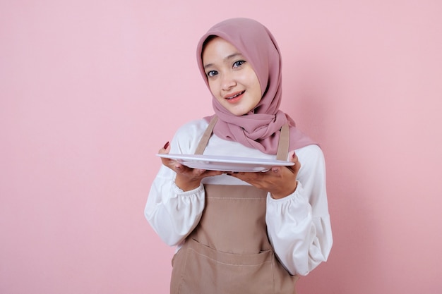 Portrait cheerful young asian woman with white dish or plate