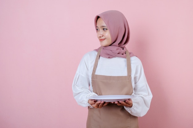 Portrait cheerful young asian woman with white dish or plate