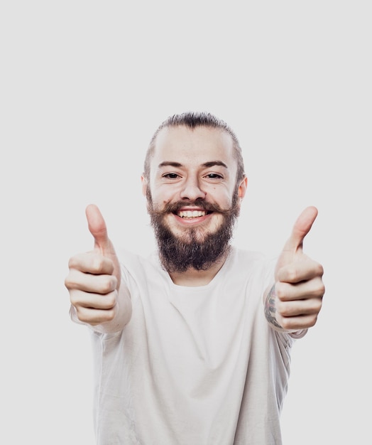 Портрет веселого молодого бородатого мужчины, показывающего нормальный жест на белом фоне