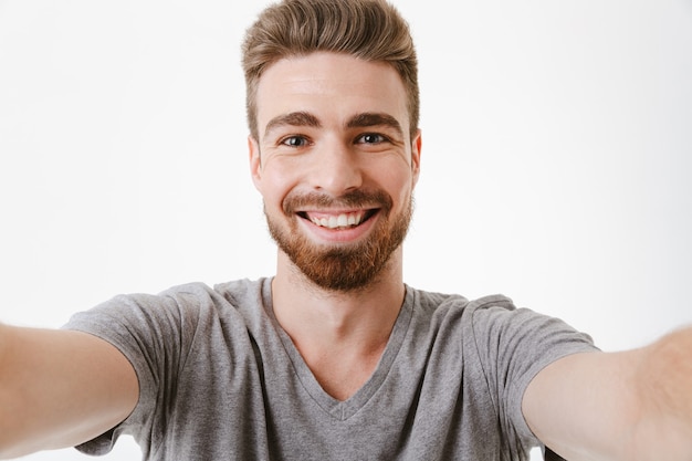 Portrait of a cheerful young bearded man taking a selfie