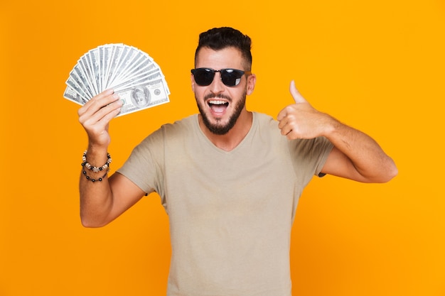 Portrait of a cheerful young casual man in sunglasses