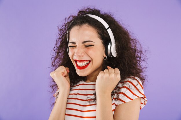 Portrait of a cheerful young casual woman listening to music