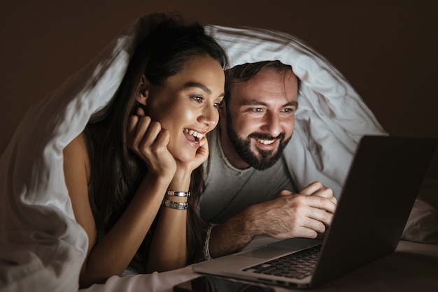 Portrait of a cheerful young couple using laptop computer