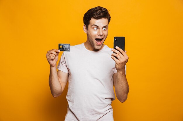 Portrait of a cheerful young man holding mobile phone