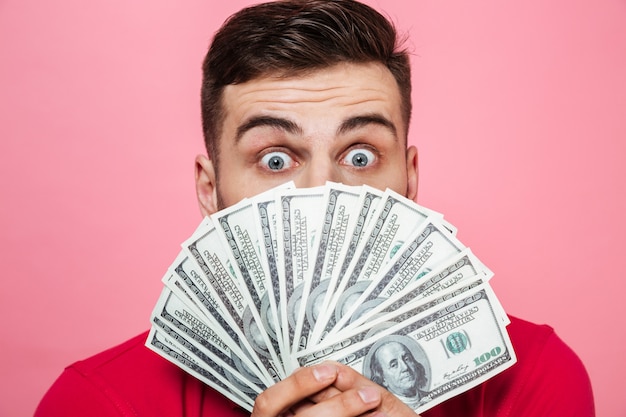 Portrait of a cheerful young man holding money banknotes