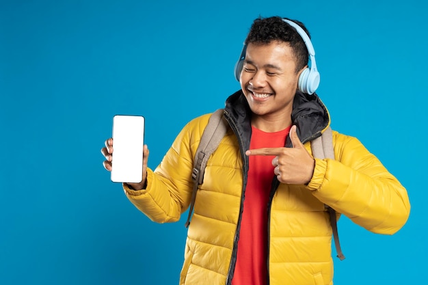 Портрет веселого молодого человека с пустым экраном мобильного телефона
