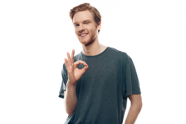 Portrait of cheerful young man showing ok gesture