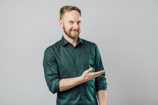 Portrait of cheerful young man smiling pointing finger