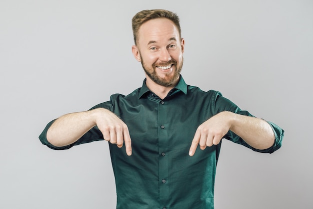 Portrait of cheerful young man smiling pointing finger