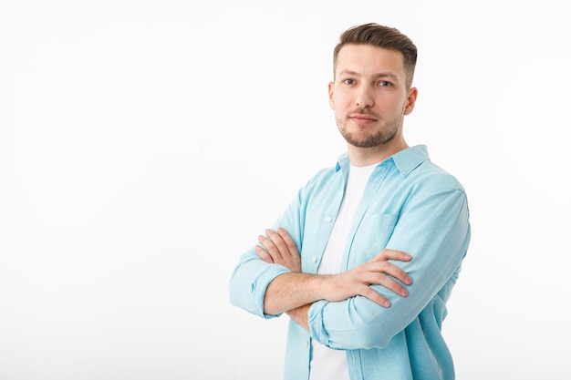 Photo portrait of a cheerful young man in a white tshirt on a white background the guy is standing looking at the camera and smiling