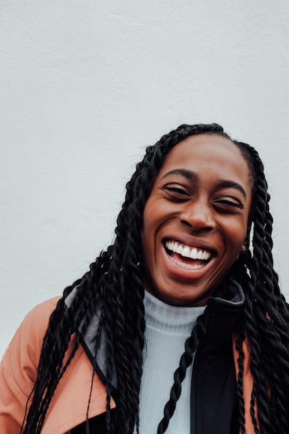 portrait of cheerful young woman against wall