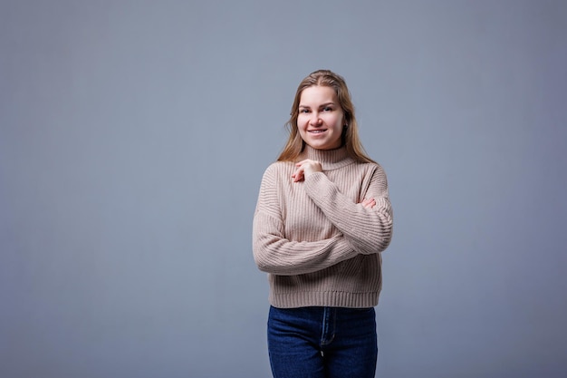 Portrait of a cheerful young woman isolated gray wall background Positive human emotions facial expressions Advertising concept customer satisfaction