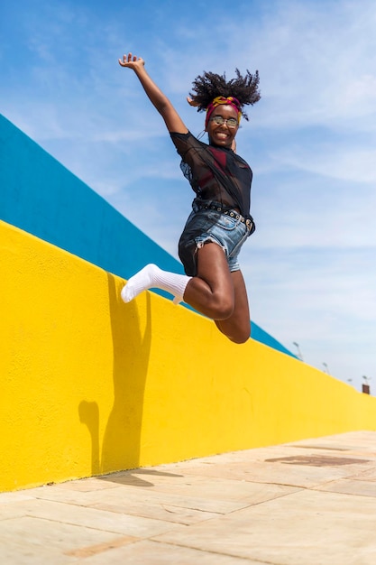 Photo portrait of cheerful young woman jumping against wall