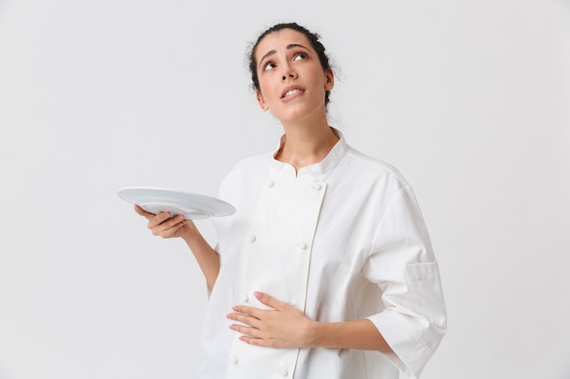 Portrait of a cheerful young woman with dishes