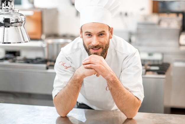 Portrait of a chef cook in uniform at the restaurant kitchen