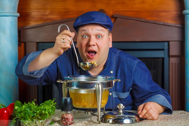 Portrait of chef with soup ladle in hand.