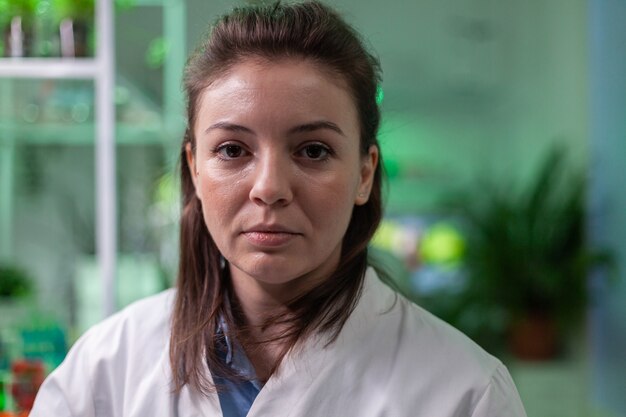 Portrait of chemist woman in white coat working in pharmaceutical laboratory