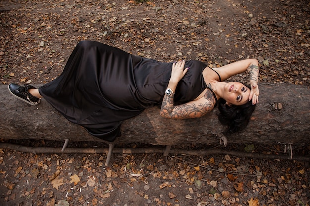 Portrait of chic darkhaired tattooed young woman